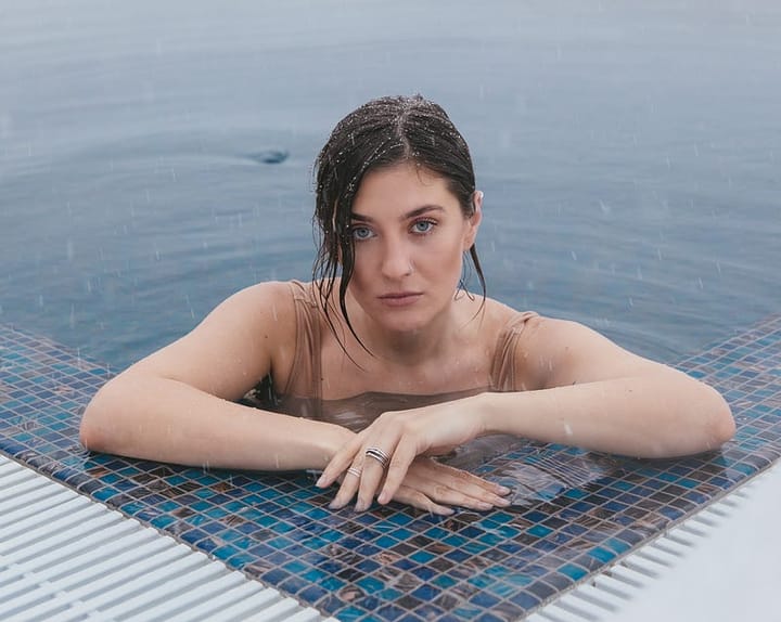 Attractive woman with blue eyes staring at the camera from the pool